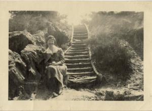 Woman sitting on steps in a trench
